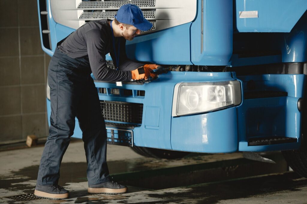 joven trabajador controla rueda mal funcionamiento camion trabajo servicio 1157 46510